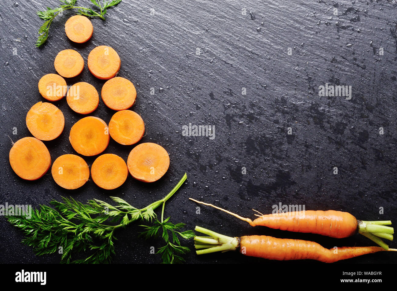 Top view at stylised christmas tree made of carrots on slate stone tray Stock Photo