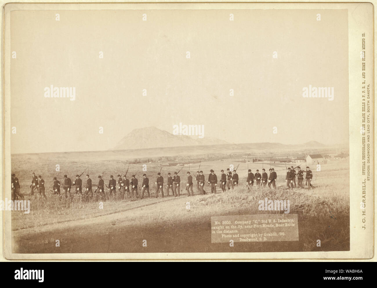 Company C, 3rd U.S. Infantry, caught on the fly, near Fort Meade. Bear Butte in the distance Stock Photo