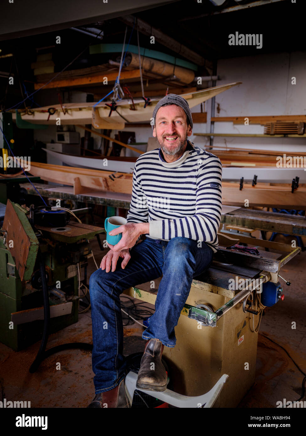 Kayak maker Chris Tipper at his workshop in Newhaven, East Sussex, UK Stock Photo