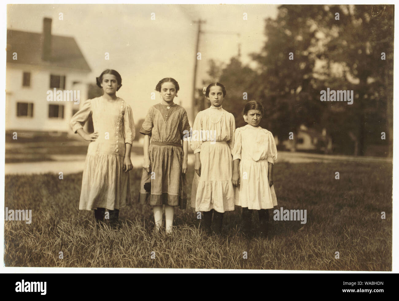 Comparison of ages: On right end is Mary Deschene, admitted 11 years, helped sister spool all summer in Glenallen Mill. Next her is Lumina Demarais, admitted 12 years, and doffing all summer in Spring Village Mill. Next is Rosina Coyette, said she was 14 but Mr. Hine doubted it; has steady job doffing and spinning in Spring Village Mill. Left end is Eva Caonette, spinner in Spring Village Mall, said she was 14 but may not be. Abstract: Photographs from the records of the National Child Labor Committee (U.S.) Stock Photo