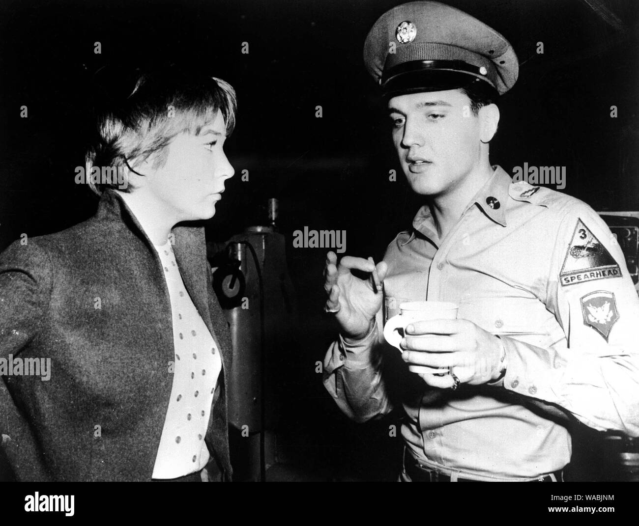 Elvis Presley, in uniform for a movie, and Shirley Maclaine during a break from filming in Hollywood (1962) File Reference # 33848-422THA Stock Photo