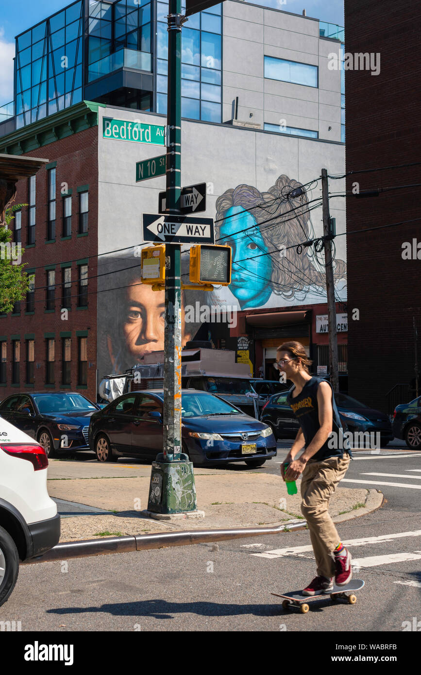 New York street, view in summer of a young person riding a skateboard in Bedford Avenue in Williamsburg, Brooklyn, New York City, USA Stock Photo