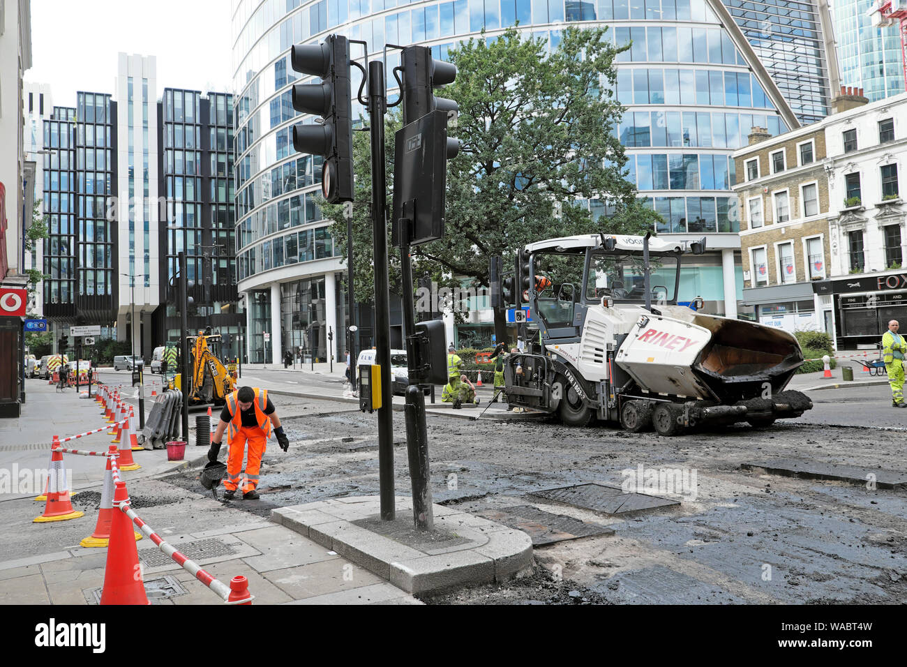 Road repair workers resurfacing street with tarmac at London Wall and ...