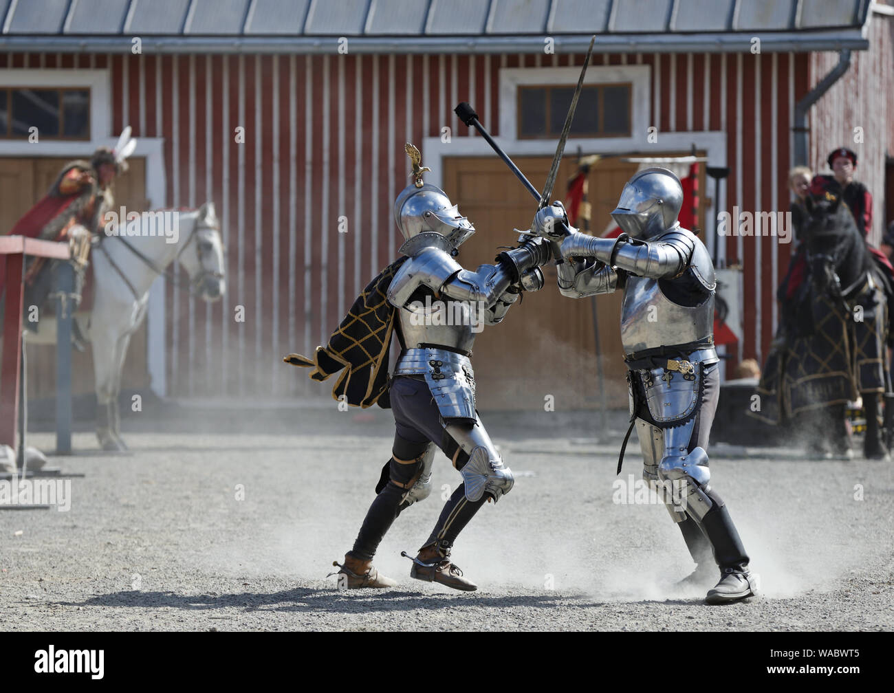 Hameenlinna Finland 08/17/2019 Medieval festival with craftsman, knights and entertainers. Two knights in harness fighting on a dusty field. Stock Photo
