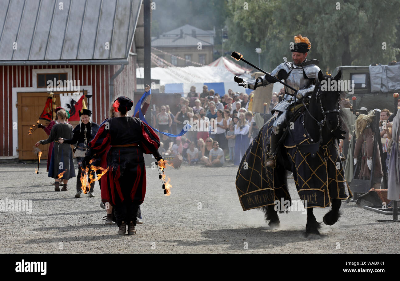 Hameenlinna Finland 08/17/2019 Medieval festival with craftsman, knights and entertainers.  A knight on the horseback greeting jesters and maidens Stock Photo