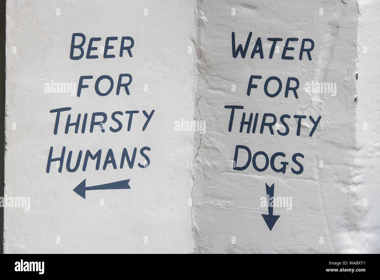 Beer for thirsty humans, water for thirsty dogs. Hand painted sign on a pub wall in Cirencester, Cotswolds, Gloucestershire, England Stock Photo