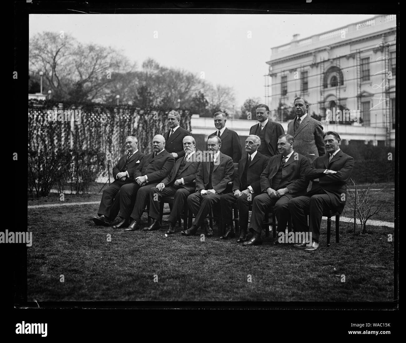 Coolidge Cabinet outside White House. Front row, left to right: Henry Stewart New, John W. Weeks, Charles Evans Hughes, Calvin Coolidge, Andrew Mellon, Harlan F. Stone, and Curtis D. Wilbur. Back row, left to right: James J. Davis, Henry C. Wallace, Herbert Hoover, and Hubert Work Stock Photo