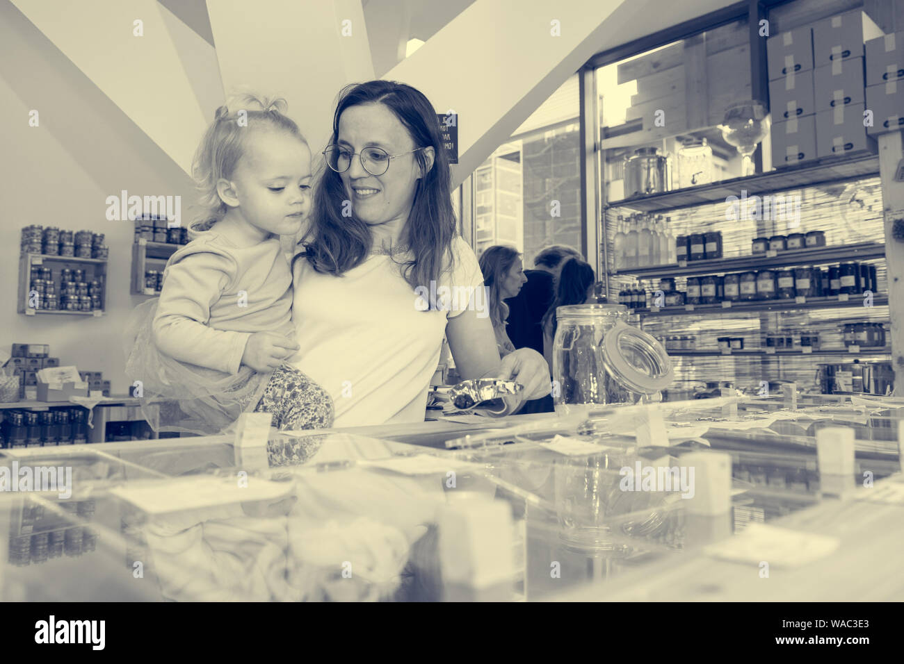 Young mother and daughter shopping in zero waste store. Raising awareness with young generations. Stock Photo