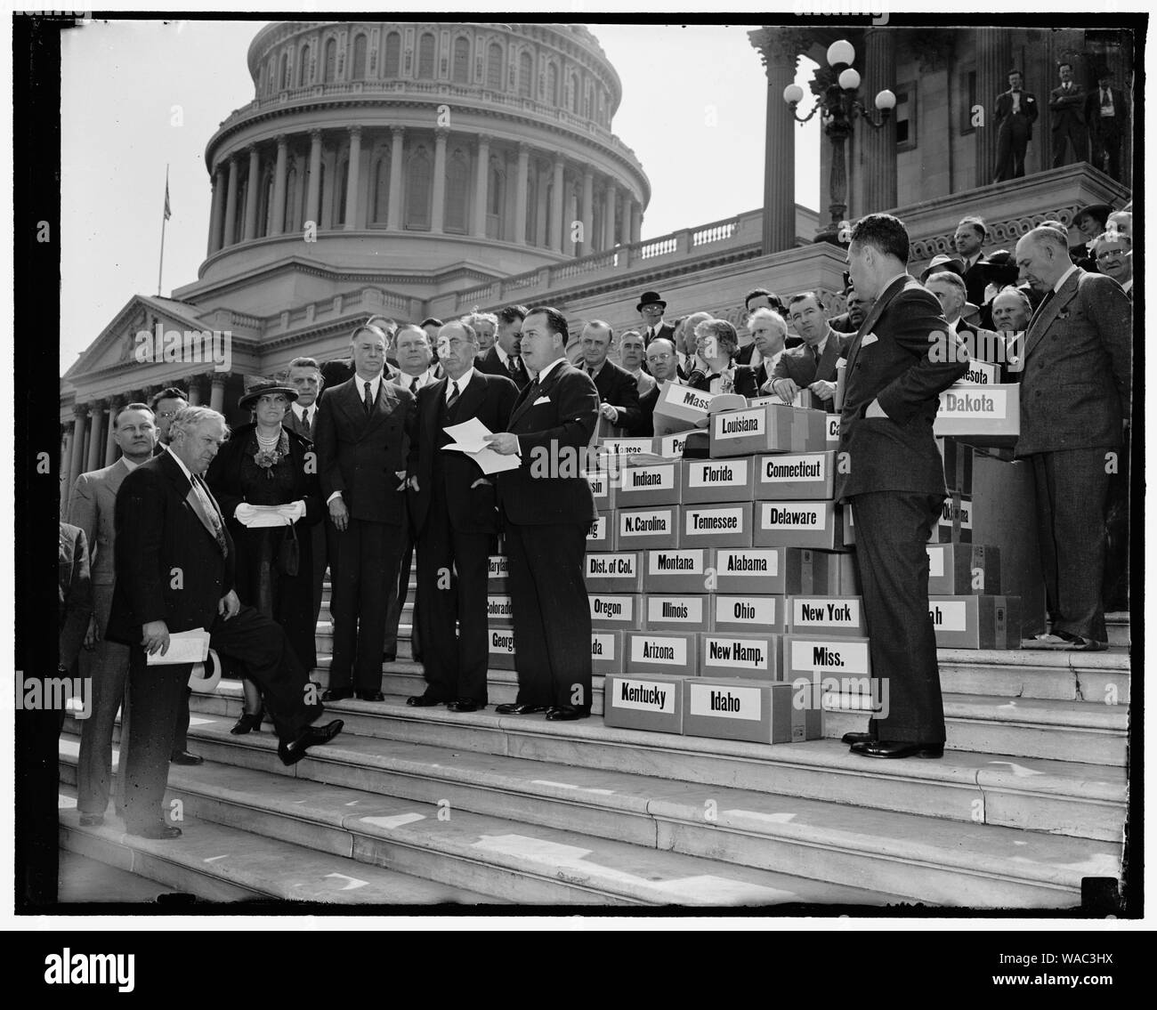 Keep America Out of War petitions presented to Congress. Washington, D.C., April 27. Keep America Out of War was keynote of four million petitions presented to members of Congress at the Capitol today by the veterans of Foreign Wars. Senator Key Pittman as President Pro Tempore of the Senate, received the petitions for the Senate. In the photograph, left to right, can be seen: Senator Pat McCarran, Nevada; Mrs Laurie M. Schertle, Nat. President, Ladies Auxiliary, Veterans of Foreign Wars; Senator Key Pittmen; Speaker of the House William D. Bankhead; and Scott P. Squires, Commander-in-Chief of Stock Photo