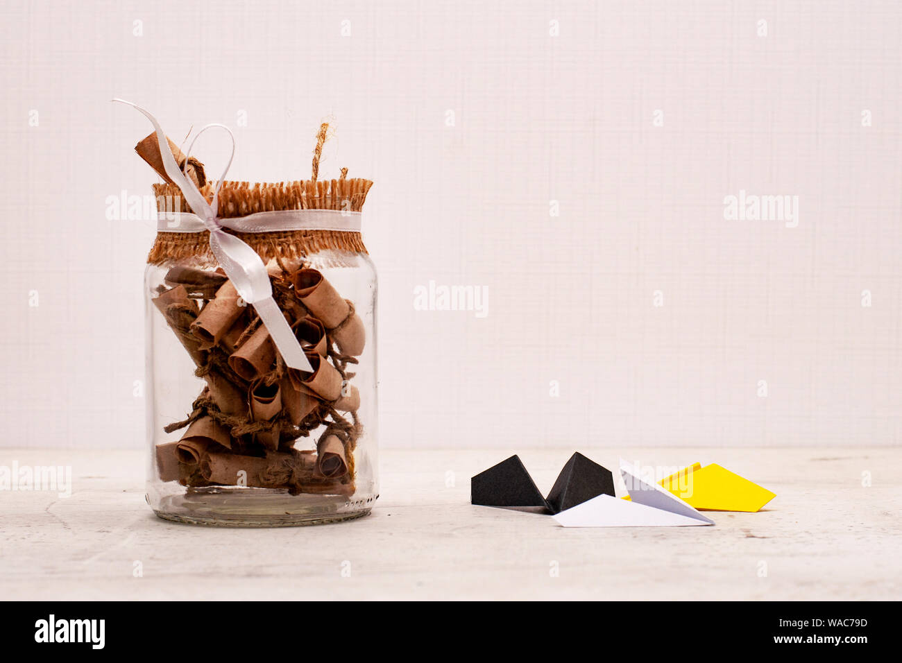 A glass jar with colored notes of craft paper. Airplanes of different