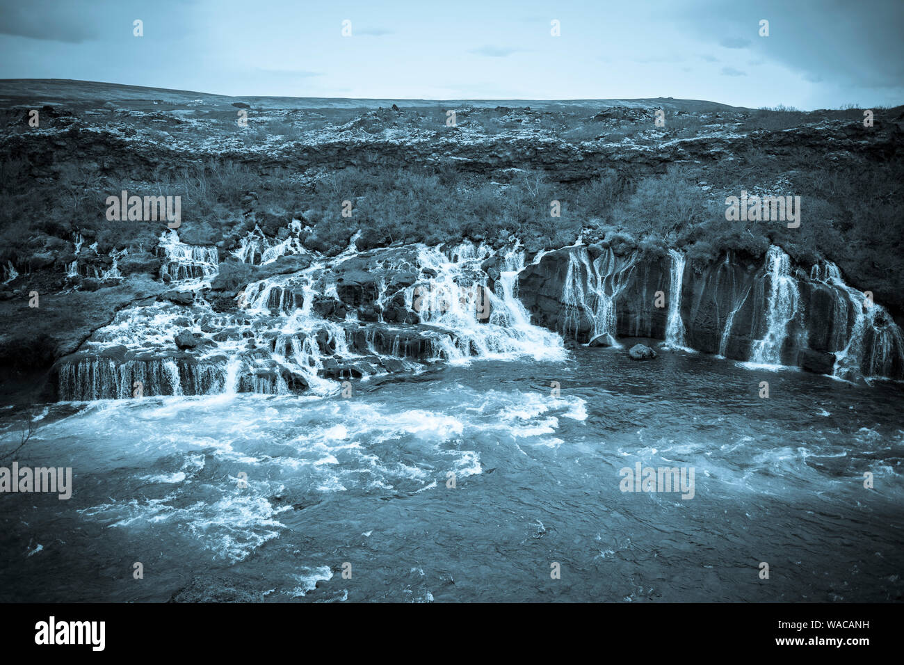 HUSAFELL, ICELAND - Hraunfossar waterfall, flowing from lava field. Stock Photo