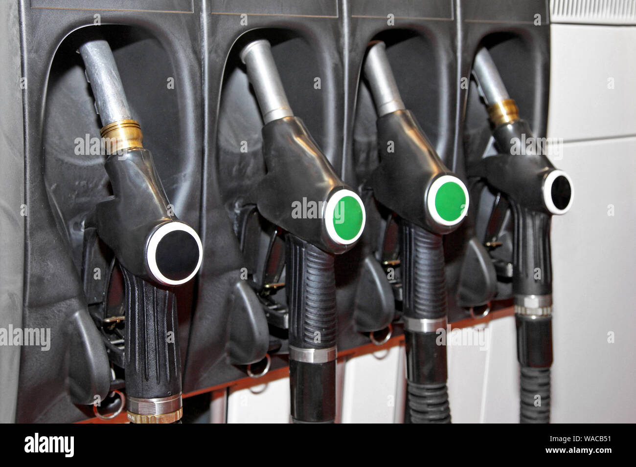 Four fuel nozzles handles at gas station Stock Photo Alamy