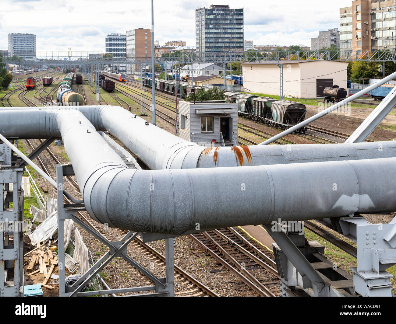 urban landscape - pipeline through railways and many trains on railroad ...