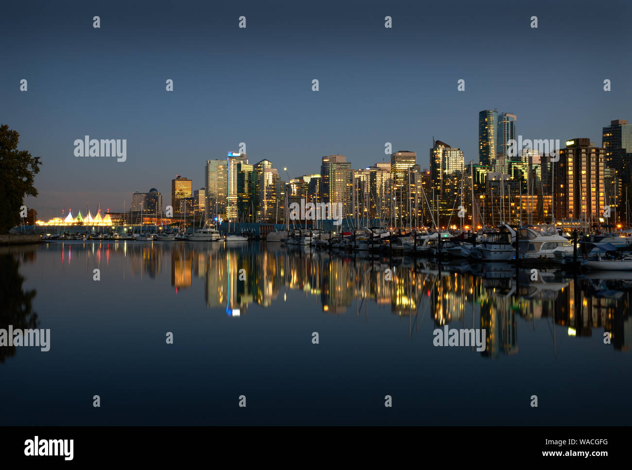 Coal Harbor Skyline Twilight Reflections. A calm Coal Harbor next to Stanley Park at twilight. Vancouver, British Columbia. Stock Photo