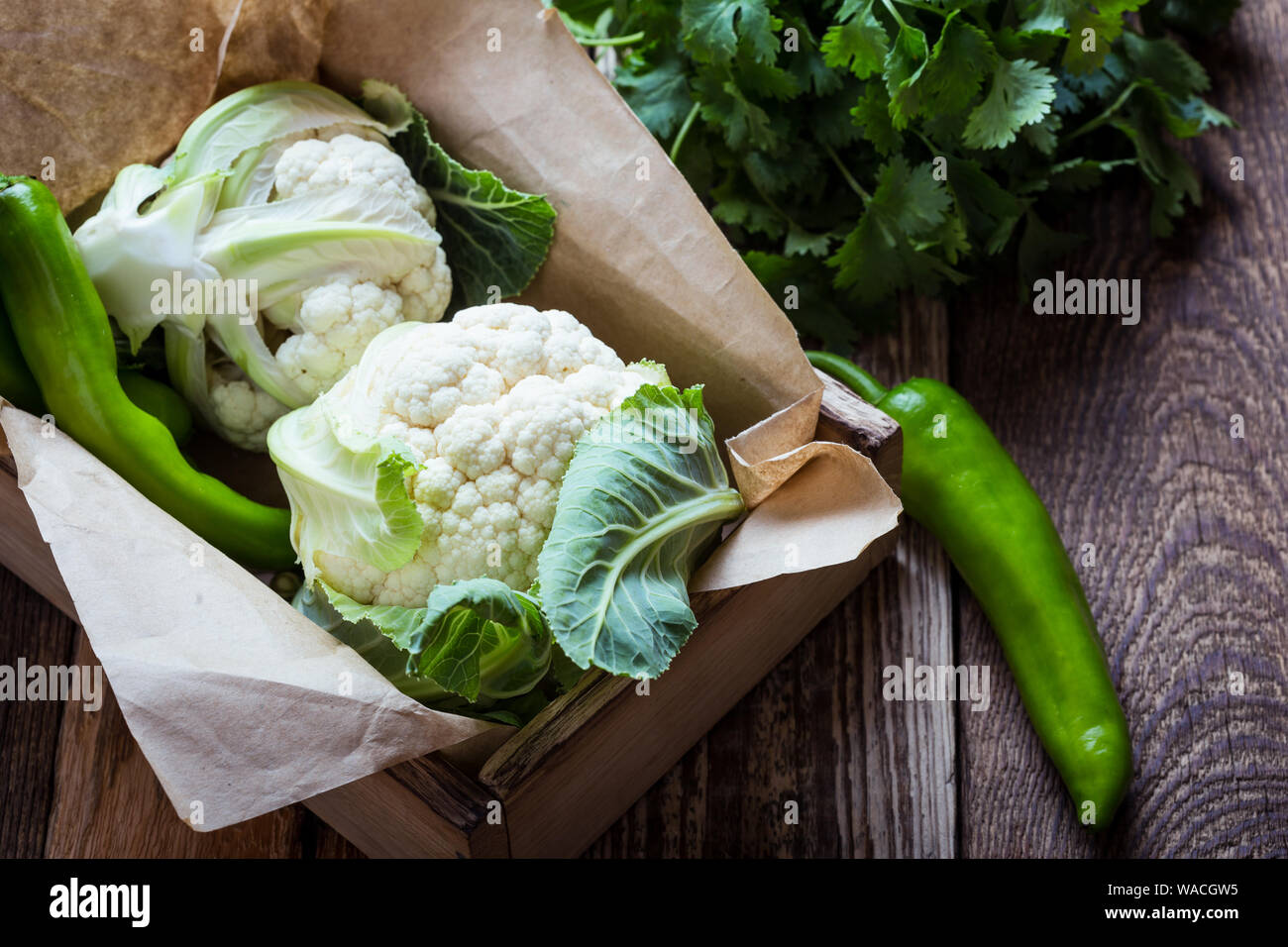 Fresh organic homegrown cauliflower in wooden crate, vegan meal, plant based food, close up, selective focus Stock Photo