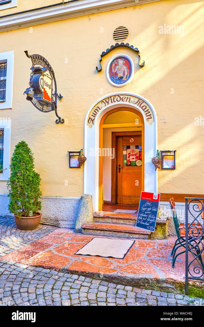 SALZBURG, AUSTRIA - FEBRUARY 27, 2019: The entrance to the historical restaurant is decorated with old frescoe and metal sign, on February 27 in Salzb Stock Photo