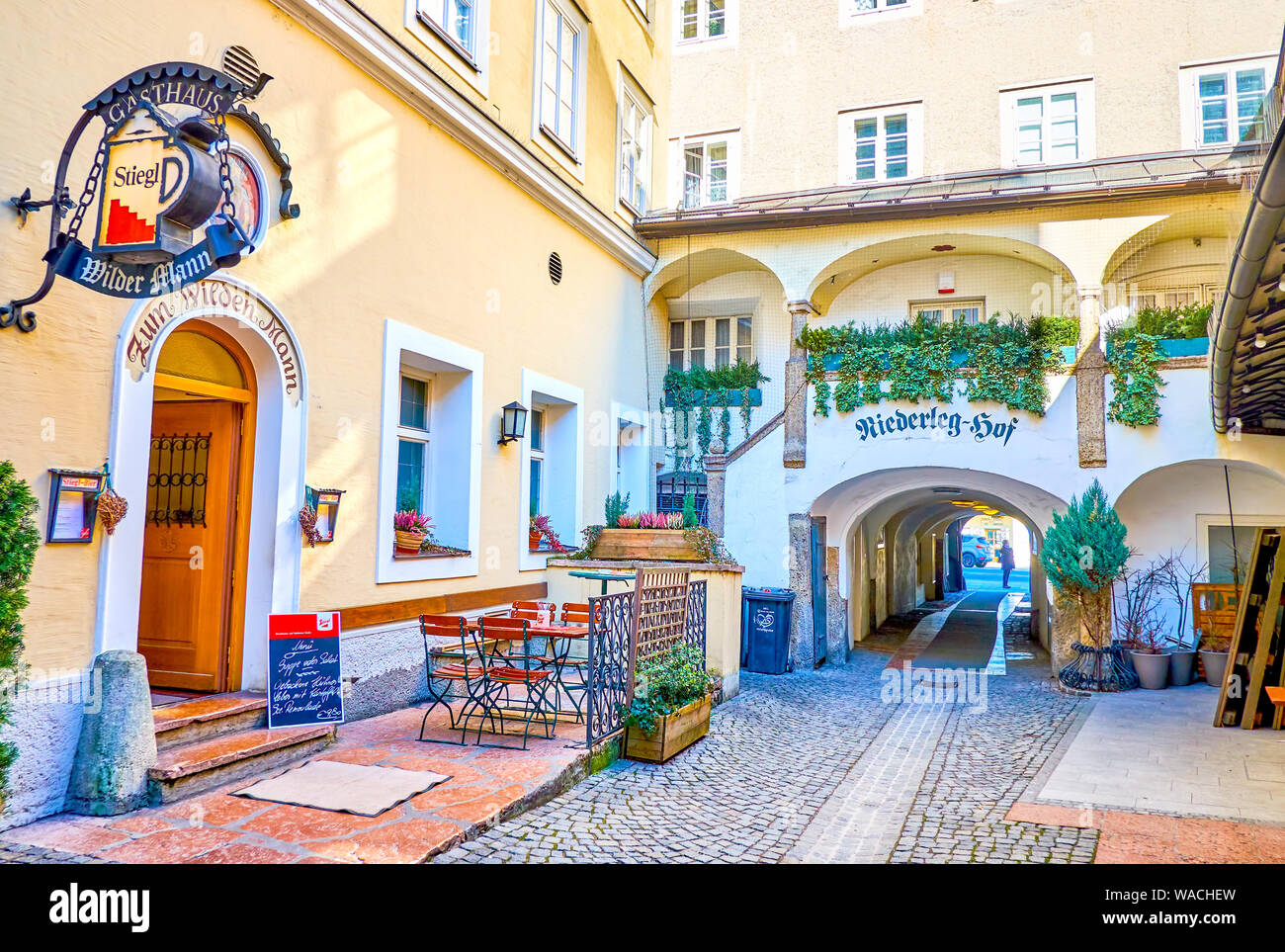 SALZBURG, AUSTRIA - FEBRUARY 27, 2019: The small inner courtyard in Altstadt with cozy restaurant's outdoor terrace, on February 27 in Salzburg Stock Photo