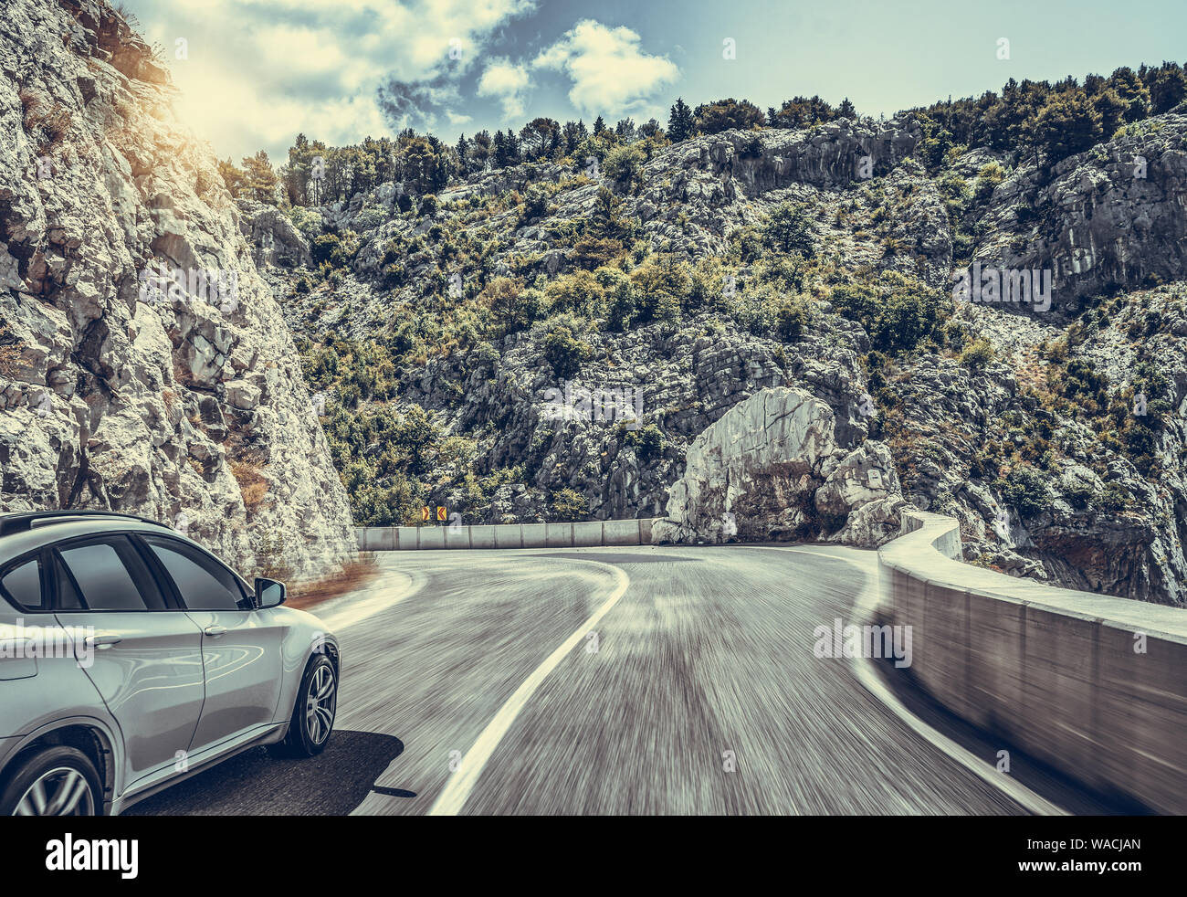 Highway among the mountain scenery. White car on a mountain road. Stock Photo