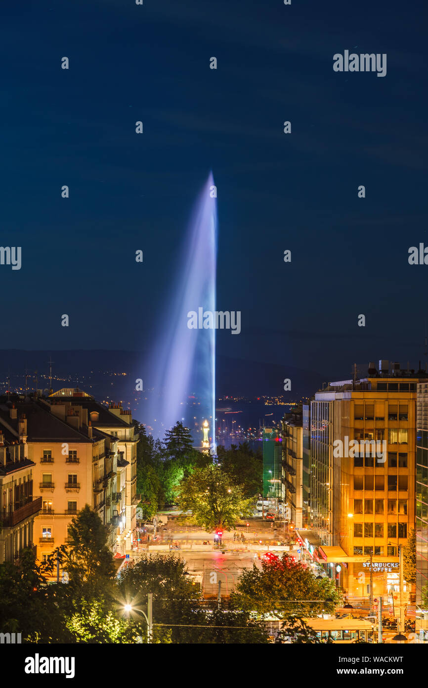 Illuminated Geneva Water Fountain (Jet d'Eau) - the city's most famous landmark - summer evening view with blue sky, Geneva, Switzerland, Europe Stock Photo