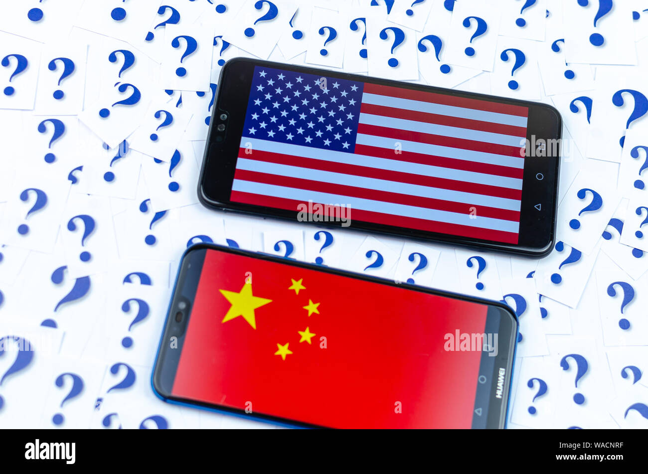 Flag of America and China on the Huawei smartphones and a lot of question marks around. The conceptual photo about future of the US China relationship Stock Photo