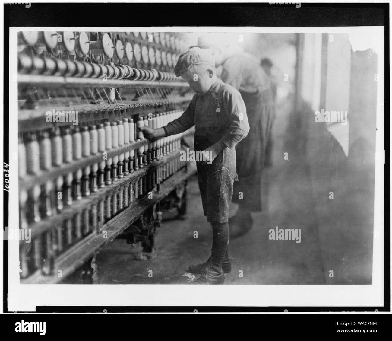 Doffer in Mellville Mfg. Co., Cherryville, N.C. Said he had been working for two years. Many of them below age. Stock Photo
