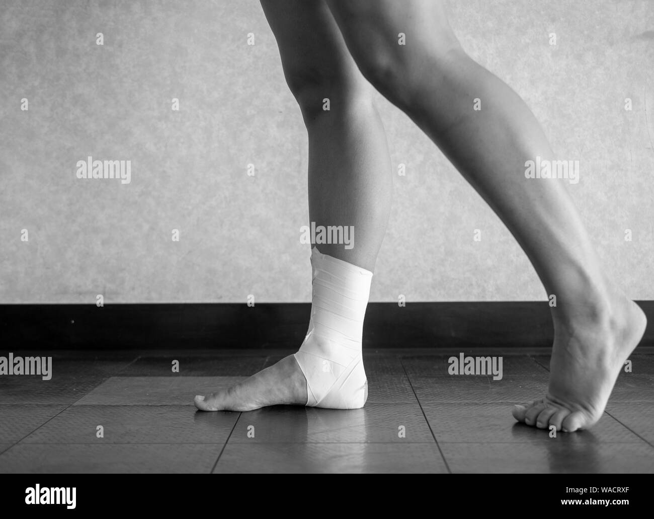 Black and white version of Inversion ankle sprain tape job in action Stock Photo