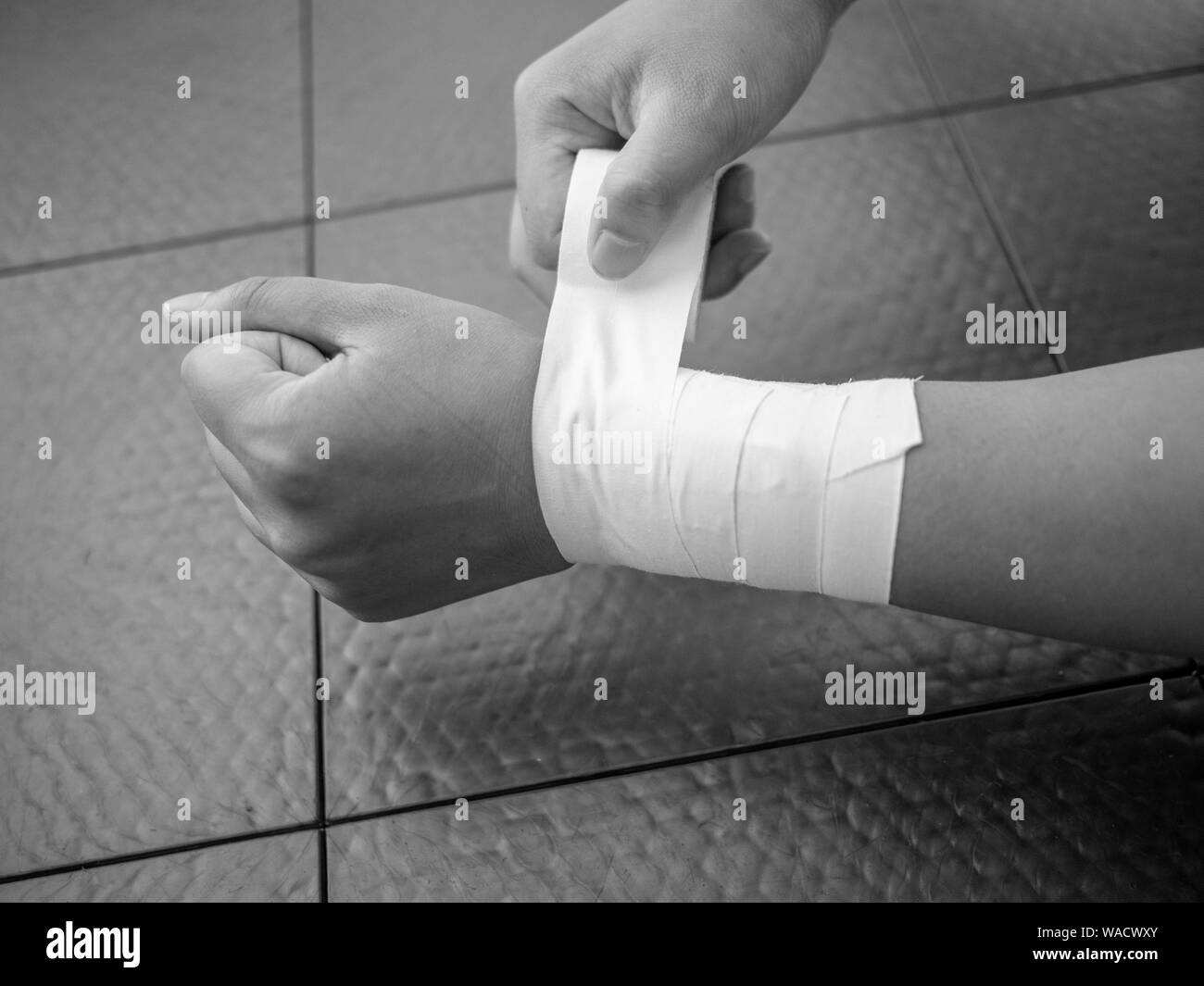 Black and white version of Athlete taping her own wrist Stock Photo - Alamy