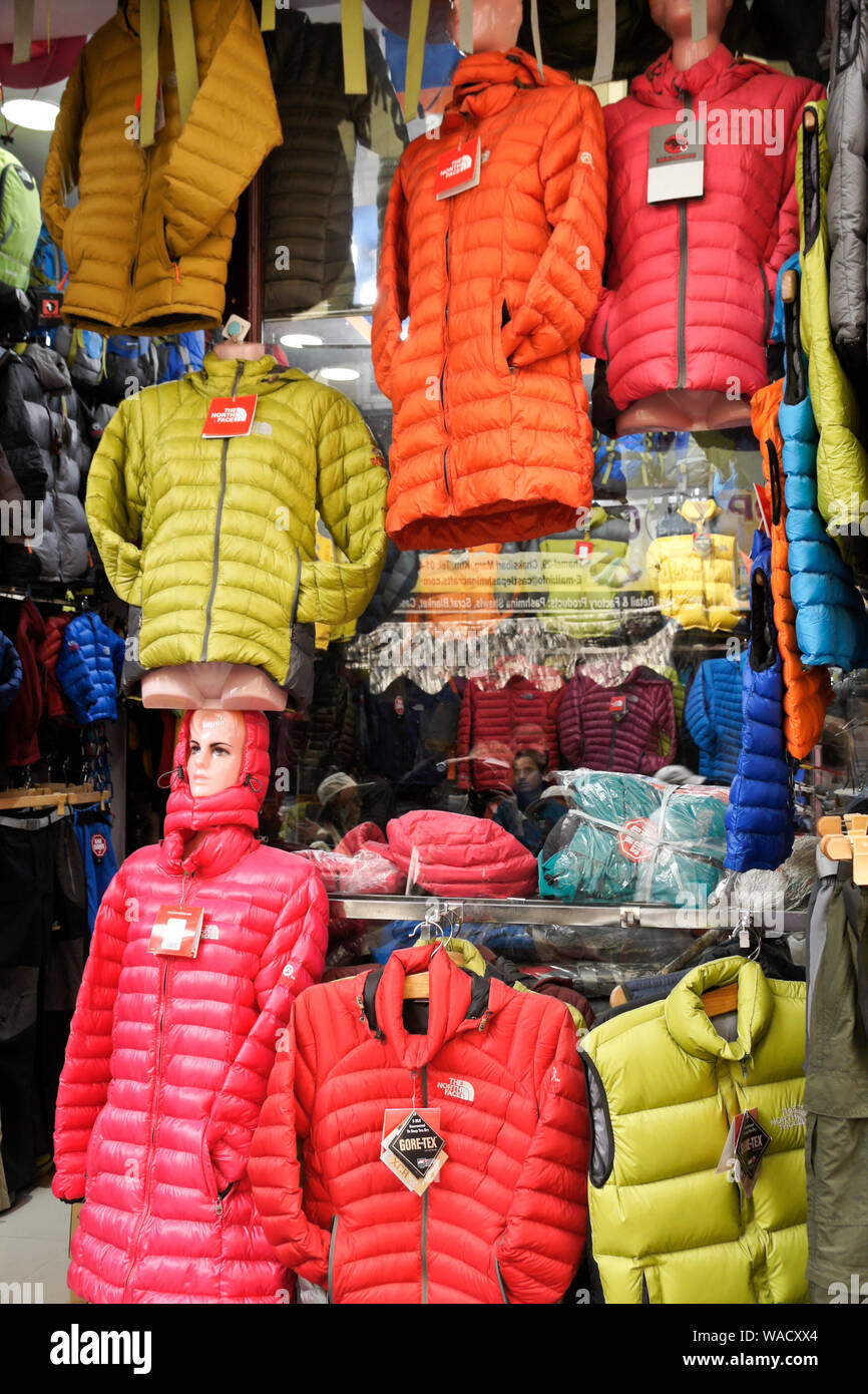 Colorful North Face quilted jackets displayed in store window in Thamel district of Kathmandu, Nepal Stock Photo