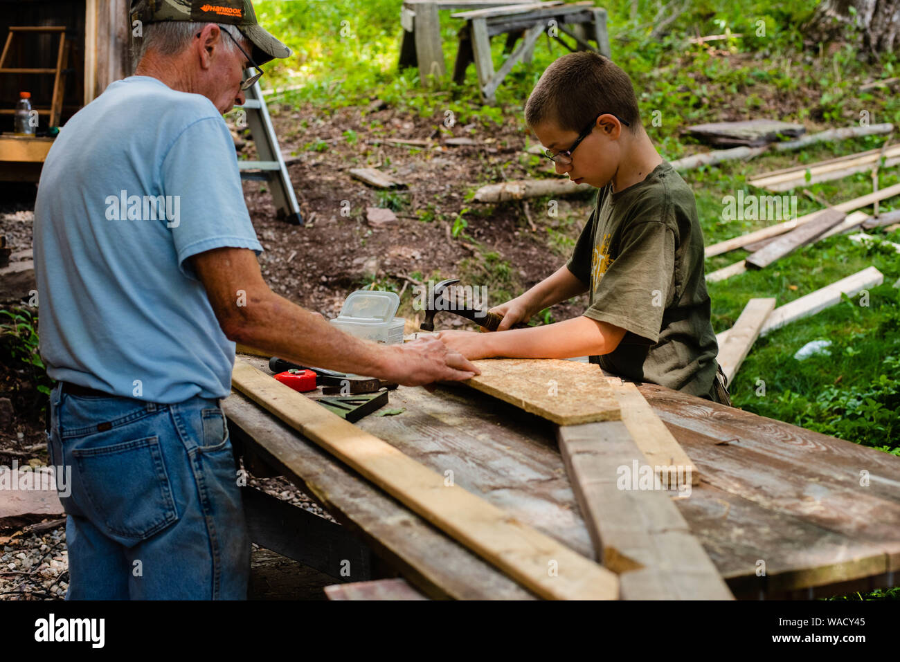 Two people work together to build a storage shed in do-it-yourself project at home. Stock Photo