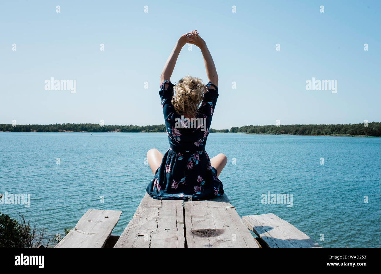 woman stretching whilst meditating in front of the sea Stock Photo