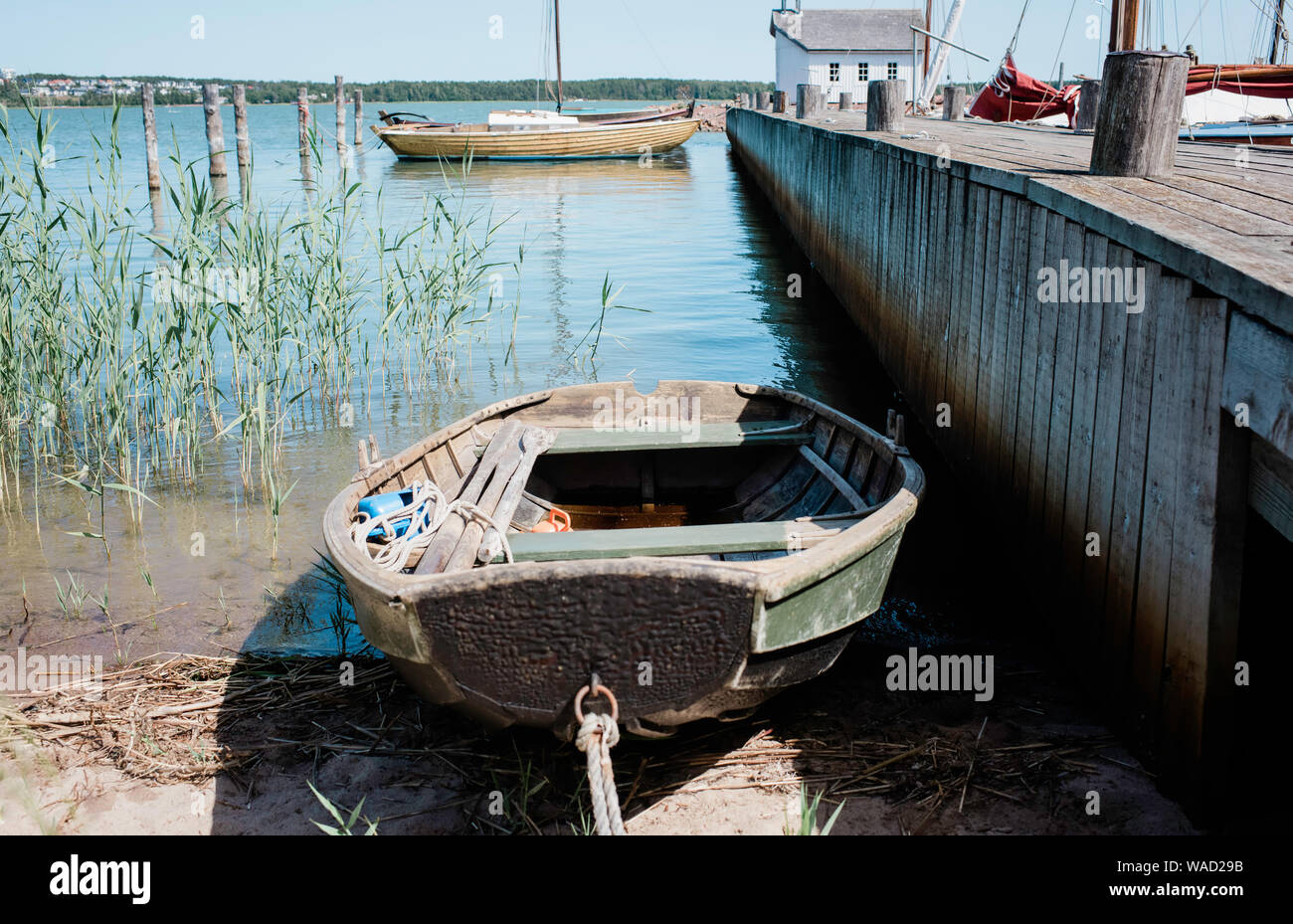 wooden rowing boat sitting on a beach at a harbour in summer Stock ...