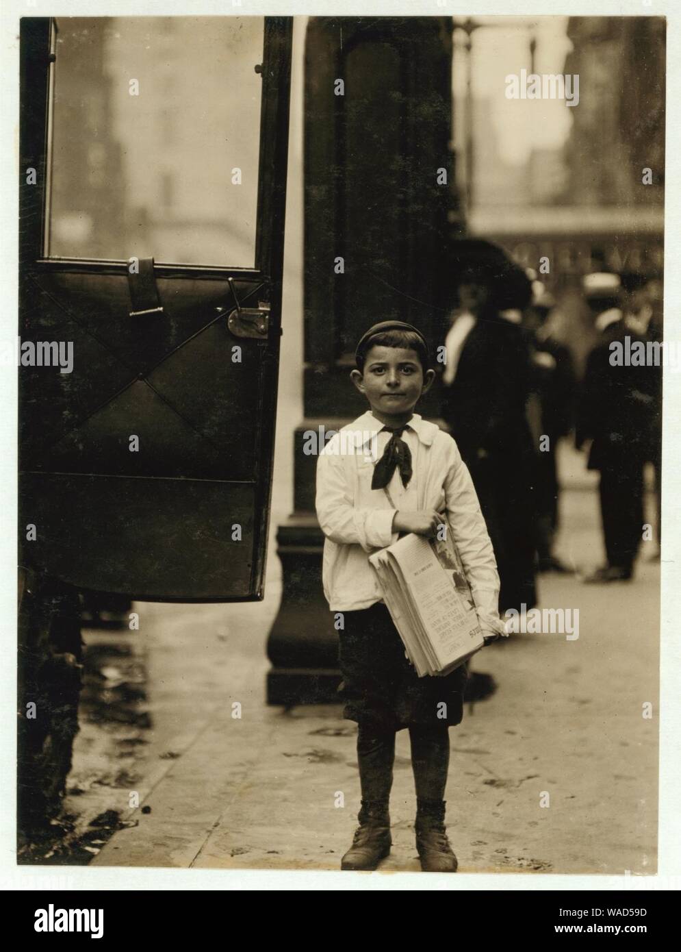 Dominick Carroll, 8 years old (appears 6). Newsboy. Sells from 3 P.M. to 7 P.M. income 25 cents per day. This boy sells papers for his brother who is 12 years old. Does not gamble, drink or Stock Photo