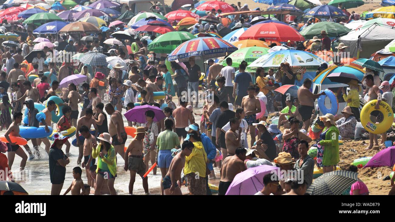 Holidaymakers crowd a beach resort to cool off on a scorching day in Dalian city, northeast China's Liaoning province, 21 July 2019. Stock Photo