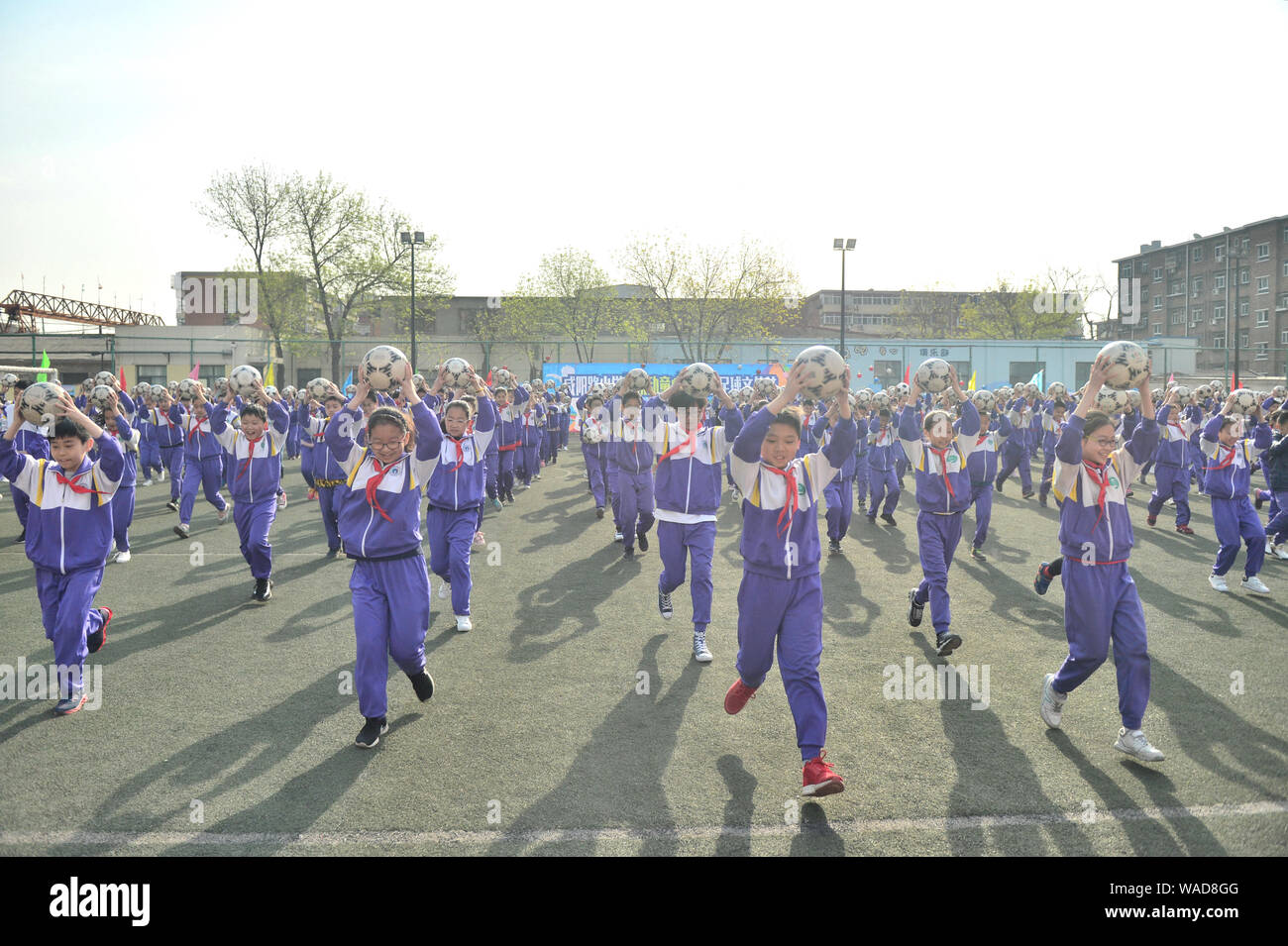 -FILE-Pupils line up to do exercise with football at the playground of Xianyang Road Primary School, Nankai district, Tianjin, China, 8 April 2019. Stock Photo