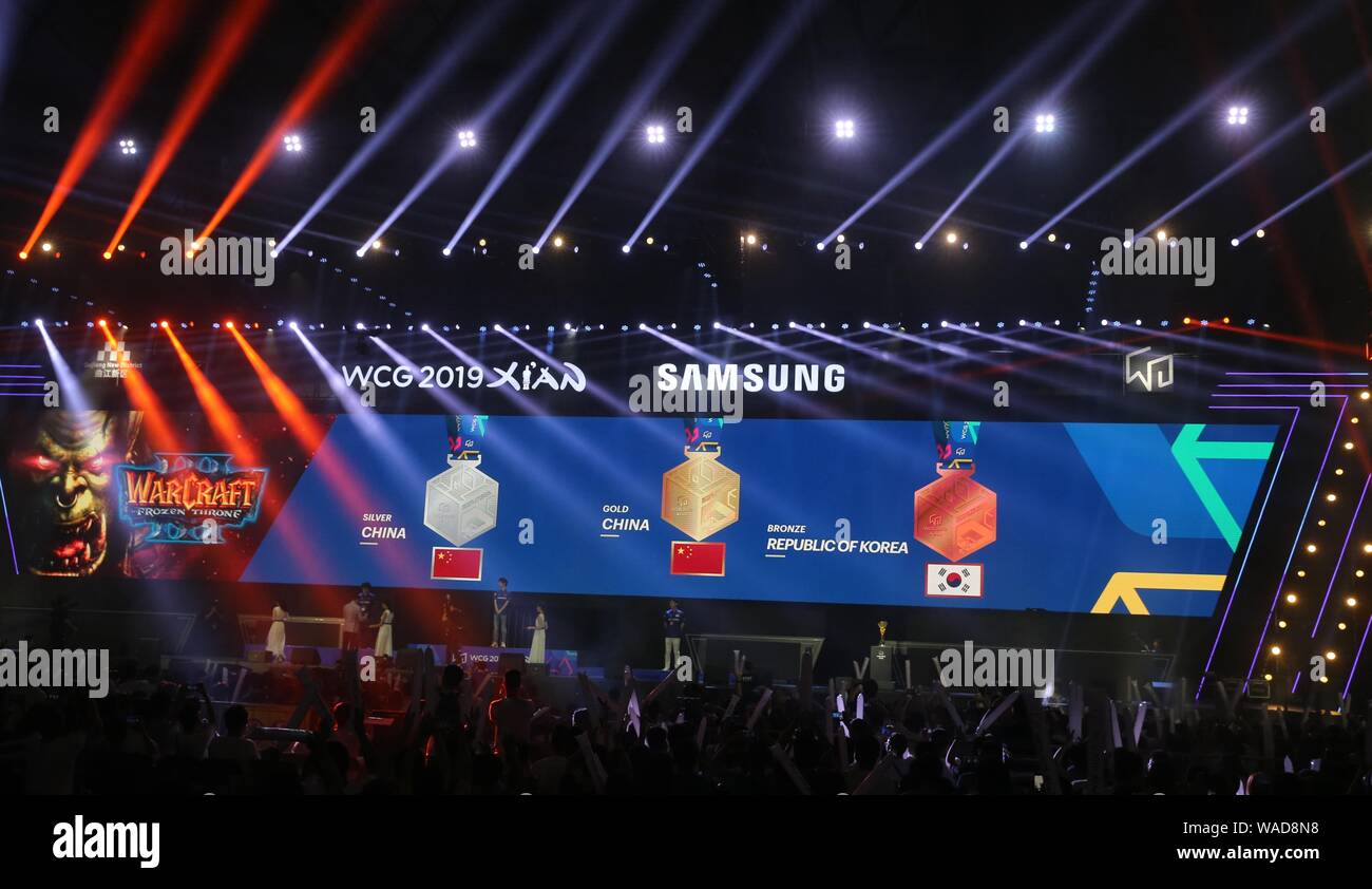 China's 2009 champion Wang 'Infi' Xuwen, center, poses with his gold medal after winning Warcraft III final during the WCG 2019 finals in Xi'an city, Stock Photo