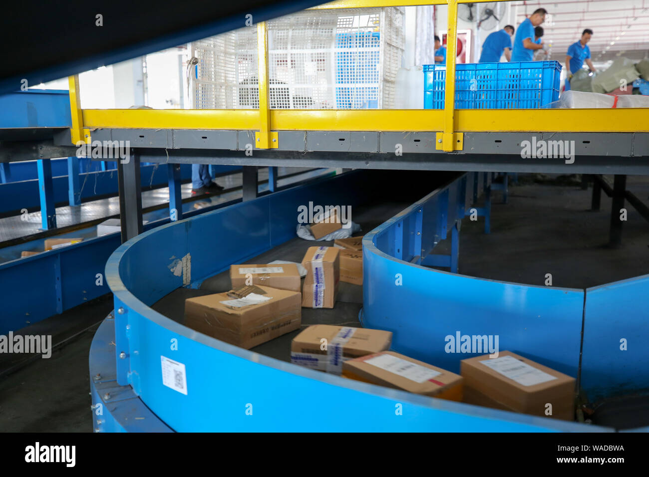 Employees work along assemble line to dispatch packages with computer