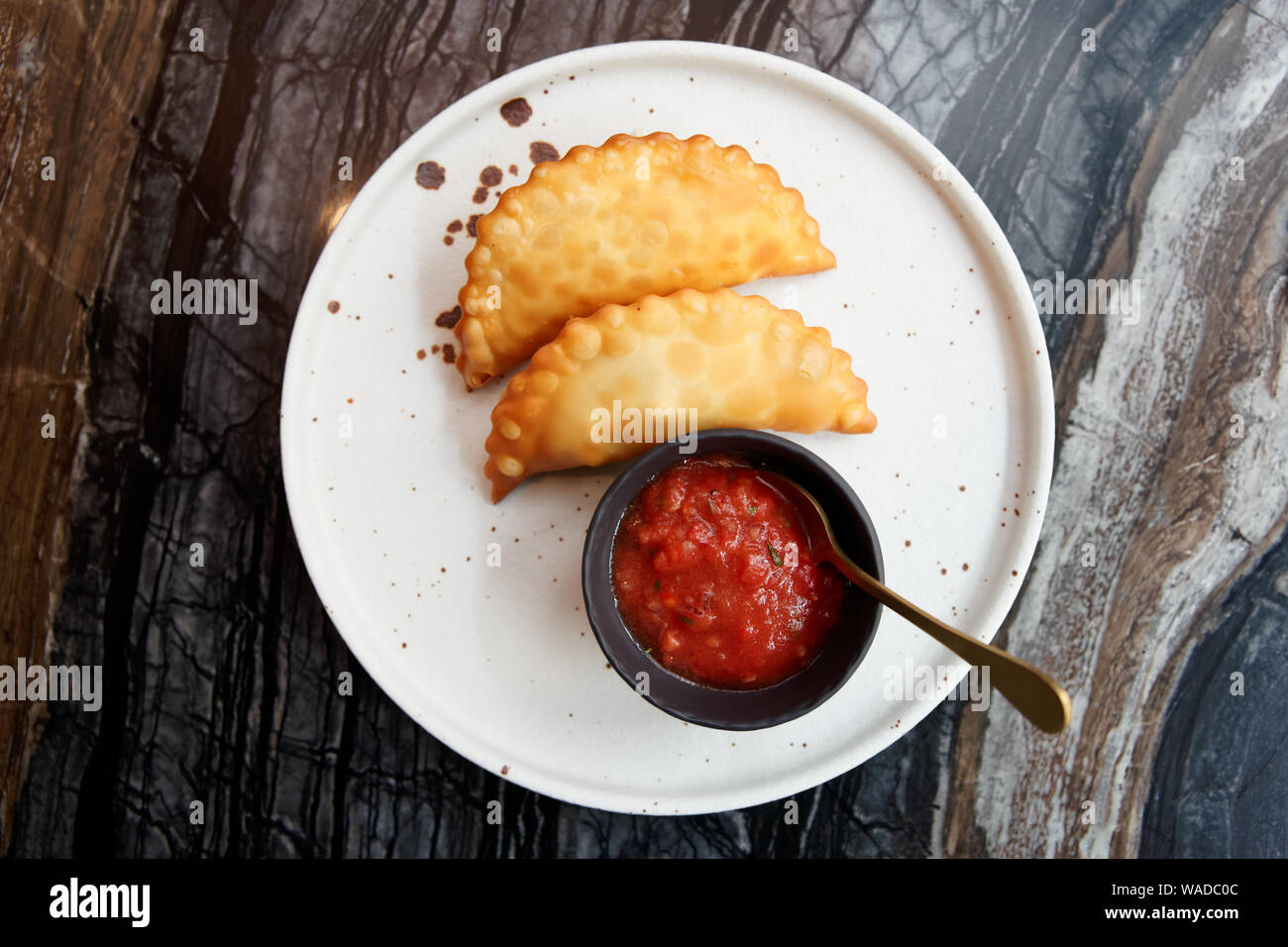Deep fried meat pastry with hot tomato sauce shot from above Stock Photo