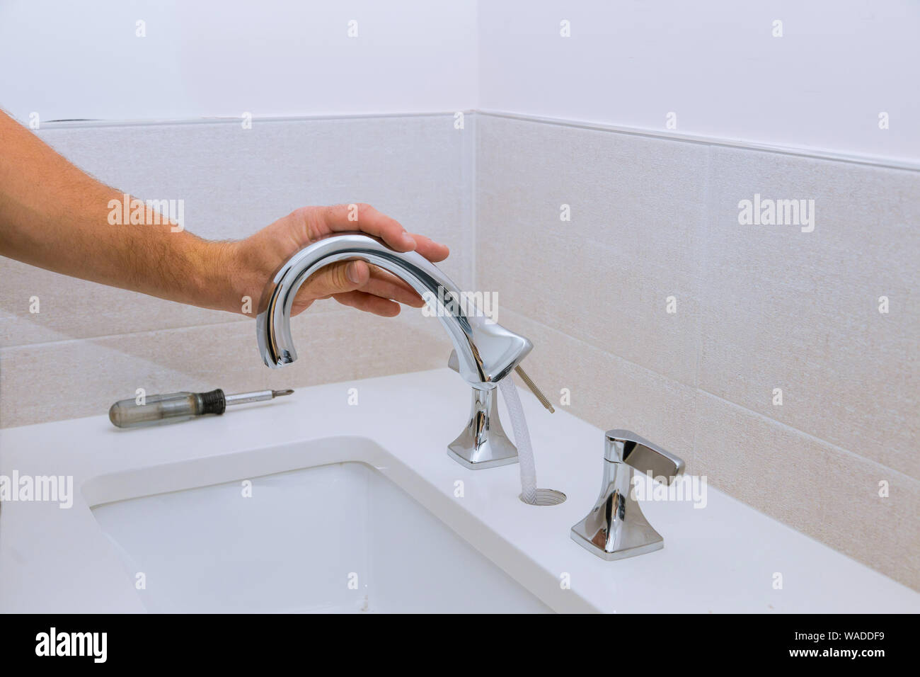 Repair service, assemble and install new faucet lies on the ceramic sink Stock Photo
