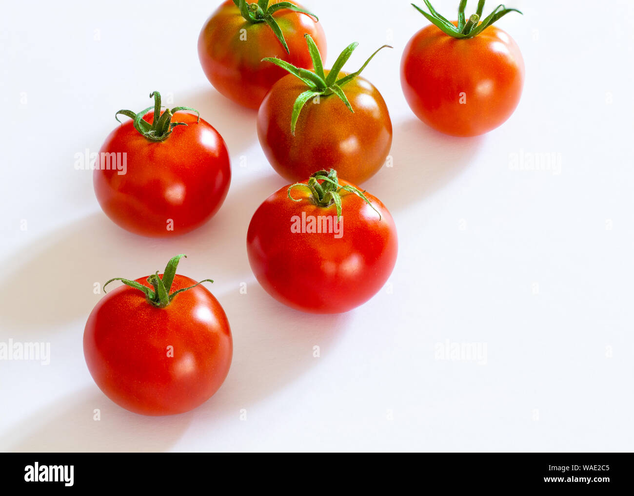 small red cherry tomatoes on white background Stock Photo - Alamy