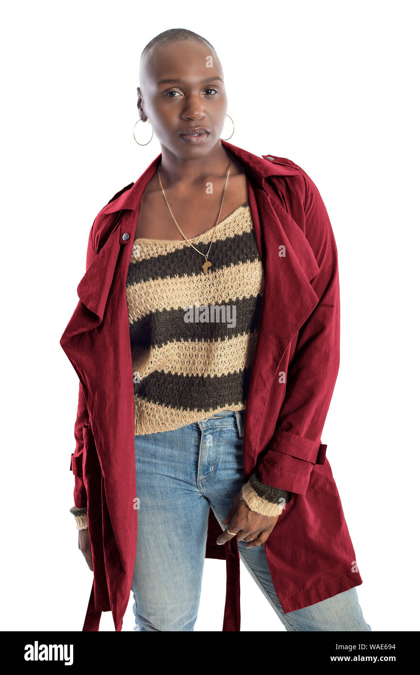 Black African American fashion model with bald hairstyle confidently posing with a red colored jacket for fall collection.  Depicts fashion design and Stock Photo