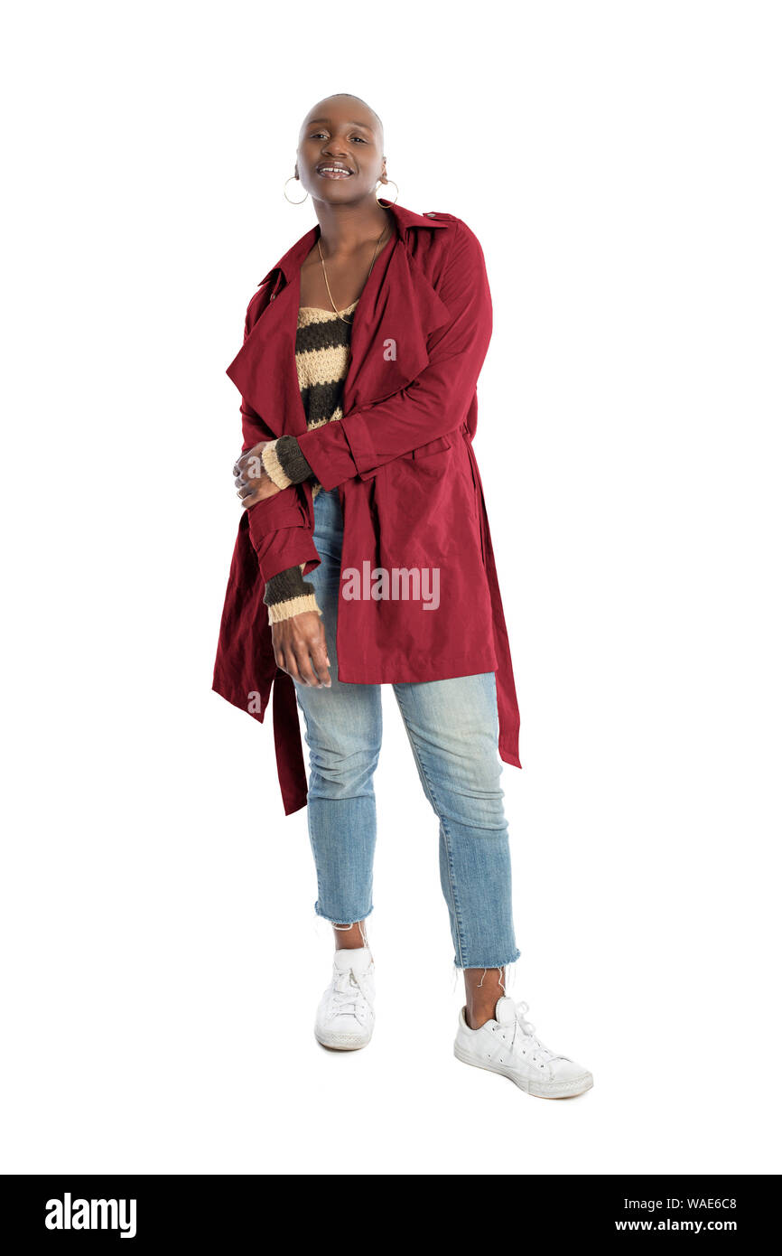 Black African American fashion model with bald hairstyle confidently posing with a red colored jacket for fall collection.  Depicts fashion design and Stock Photo