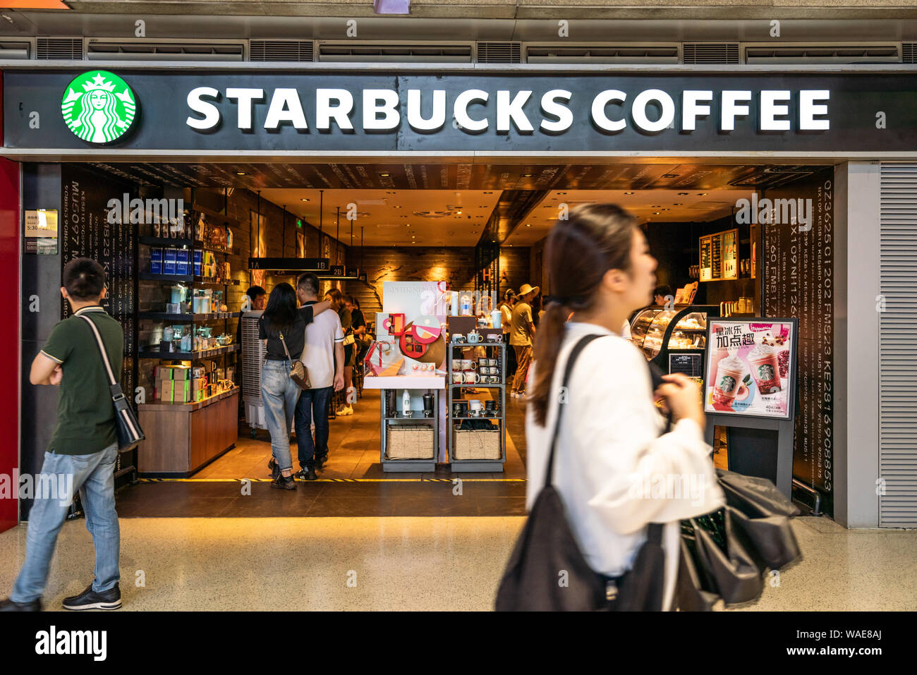 Pedestrians walk past an American coffee company and coffeehouse chain