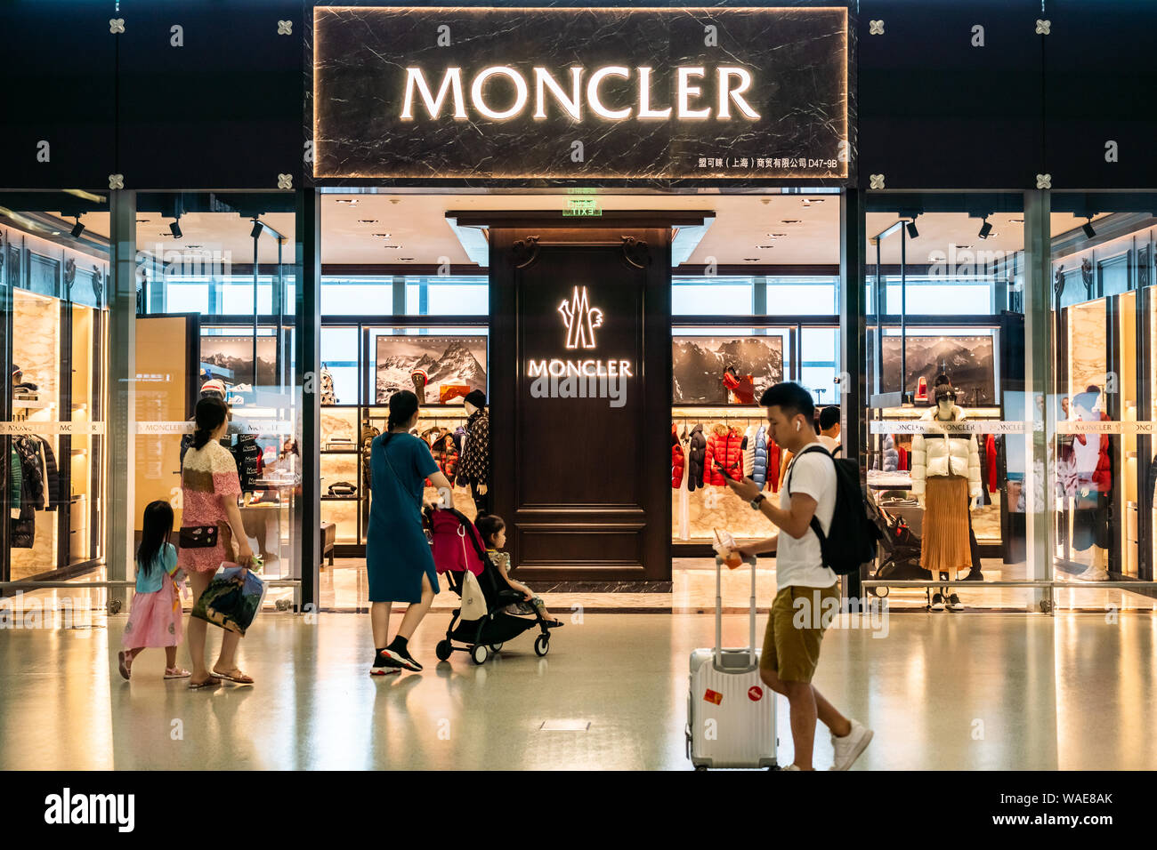 Pedestrians walk past an Italian apparel and lifestyle company Moncler store  in Shanghai Hongqiao International Airport Stock Photo - Alamy