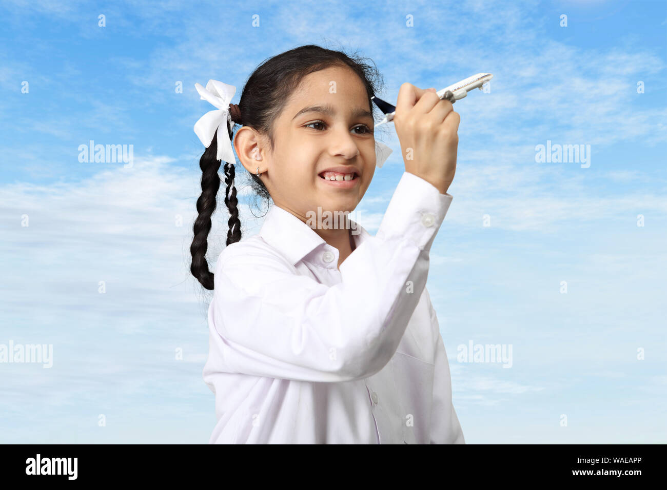 Girl pretending to be a pilot playing with model airplane Stock Photo