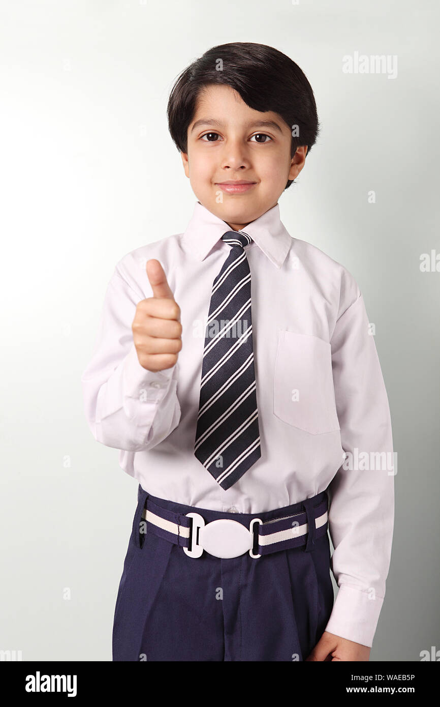 Schoolboy standing and showing thumbs up sign Stock Photo - Alamy