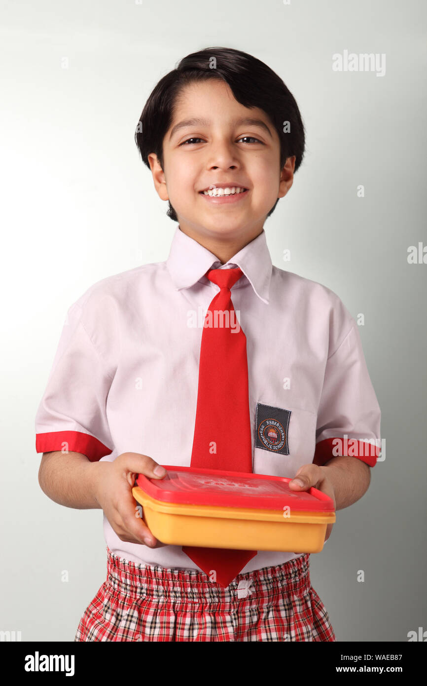 Schoolboy holding a lunch box and smiling Stock Photo Alamy