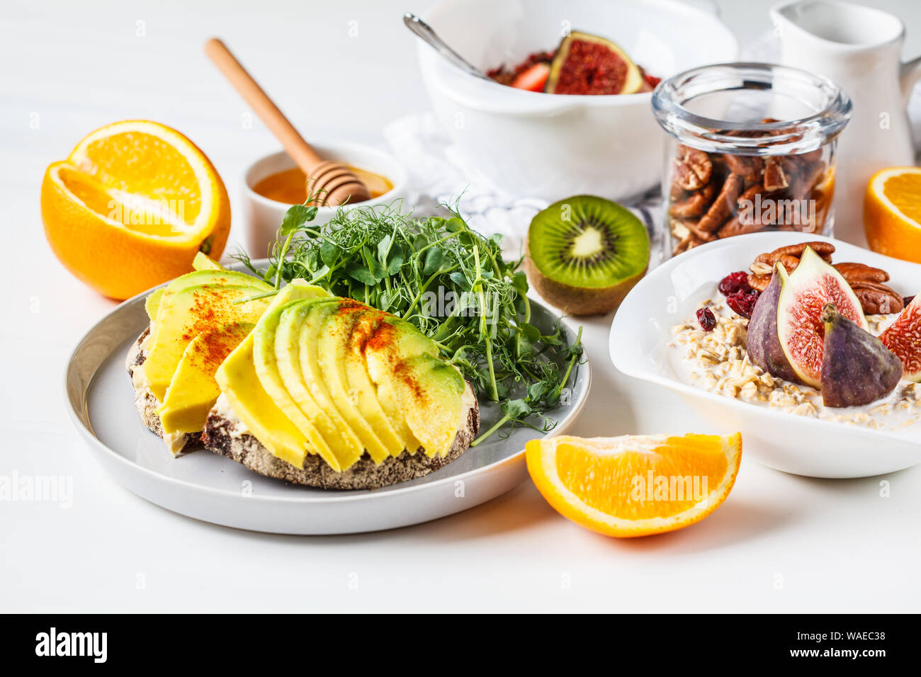  Vegan breakfast table with avocado toast, oatmeal, fruit, on a white background Stock Photo