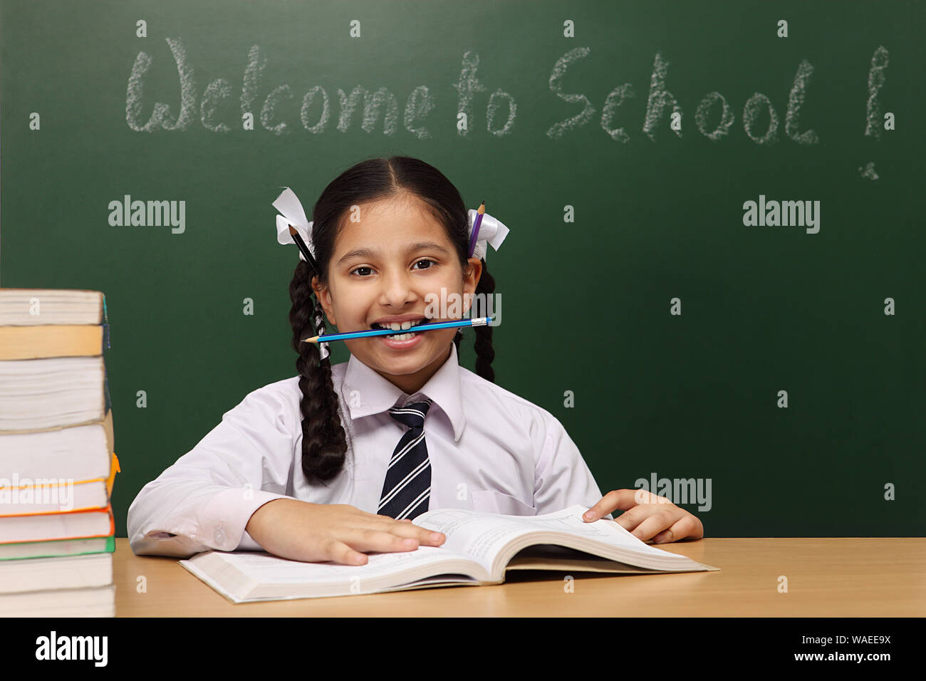 Schoolgirl holding pencil in her mouth Stock Photo - Alamy