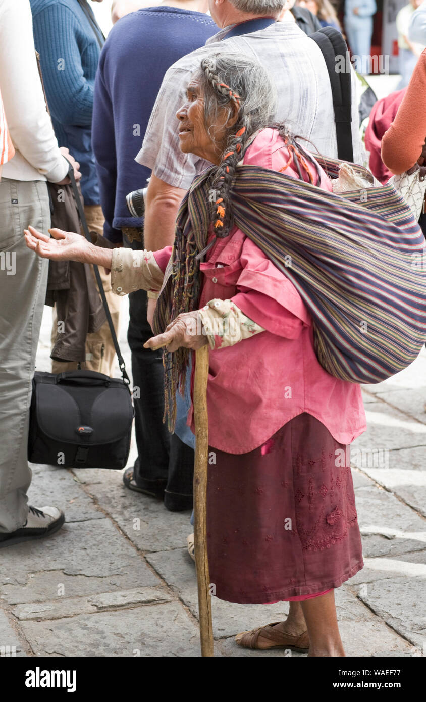 An old indigenous Mexican beggar woman begging asking tourists for money, Oaxaca City, Oaxaca, Mexico. Poor people poverty in third world. Stock Photo