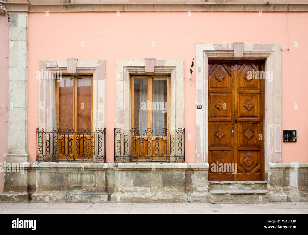 Spanish colonial building exterior with carved wooden door, casement